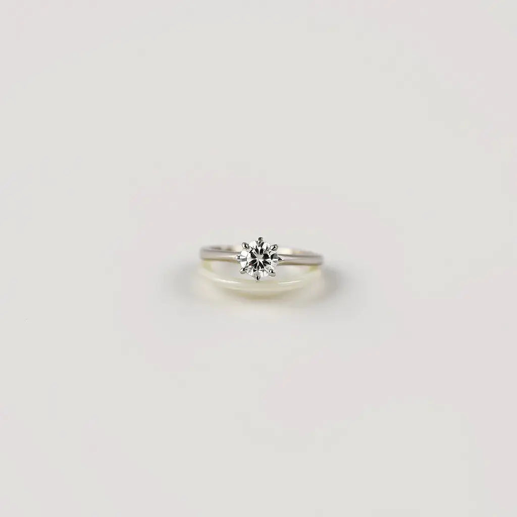 Solitaire engagement ring with a single sparkling center diamond on a slim metal band