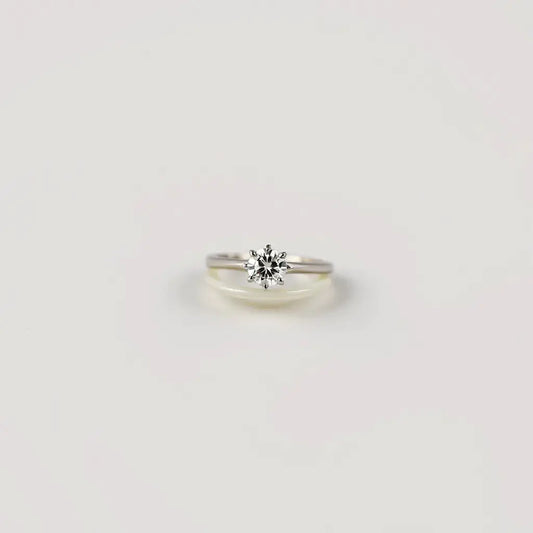 Solitaire engagement ring with a single sparkling center diamond on a slim metal band