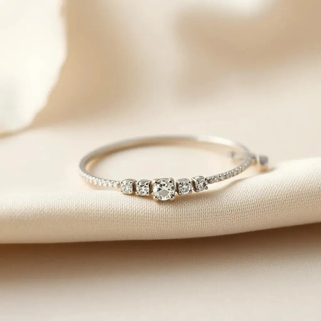 Diamond bracelet with delicate linked setting and small round stones on neutral fabric