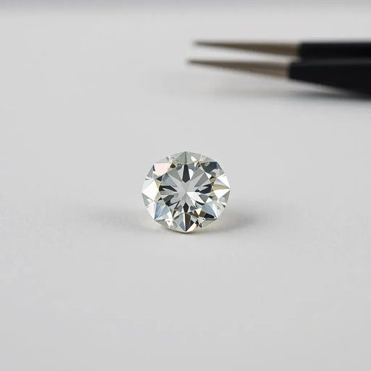 Faceted lab grown diamond resting on a neutral surface with soft studio lighting