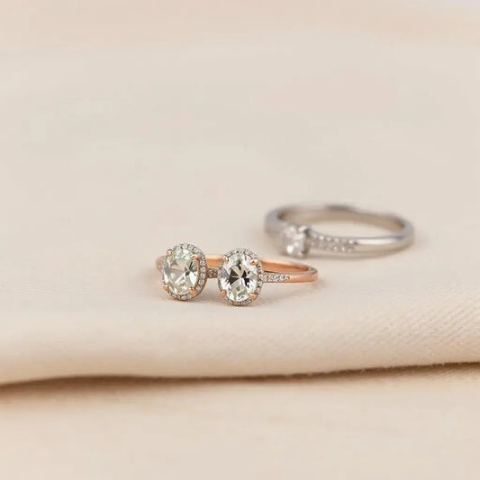 Oval engagement ring with a prong setting on neutral fabric under soft studio lighting