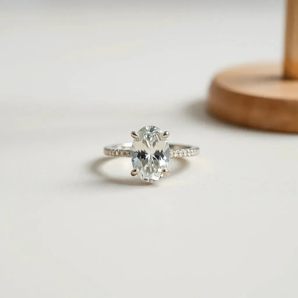 Oval-cut diamond ring with a simple band on a neutral background with soft studio lighting