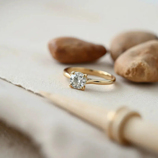 14k gold engagement ring with a solitaire gemstone on a soft neutral background