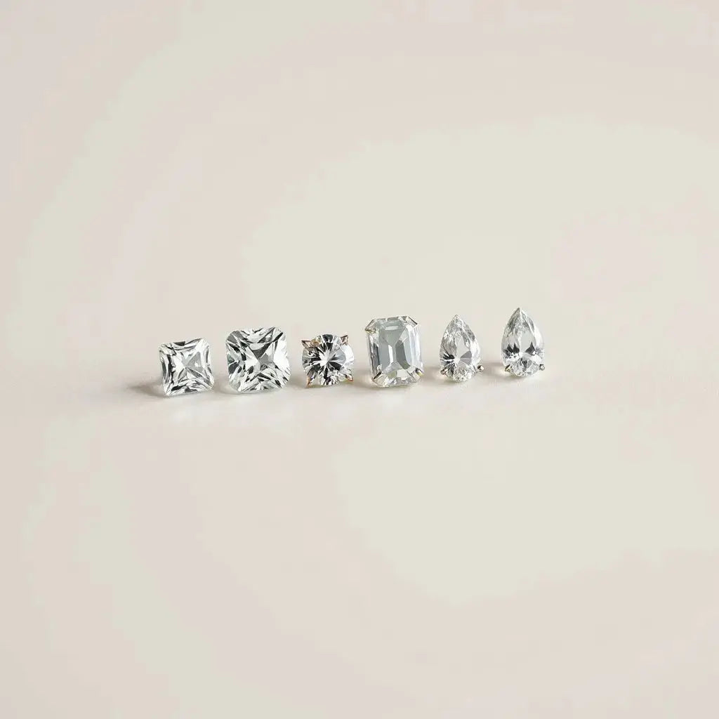 Assorted uniquely cut diamonds arranged on a neutral surface with soft studio lighting
