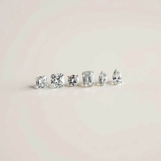 Assorted uniquely cut diamonds arranged on a neutral surface with soft studio lighting