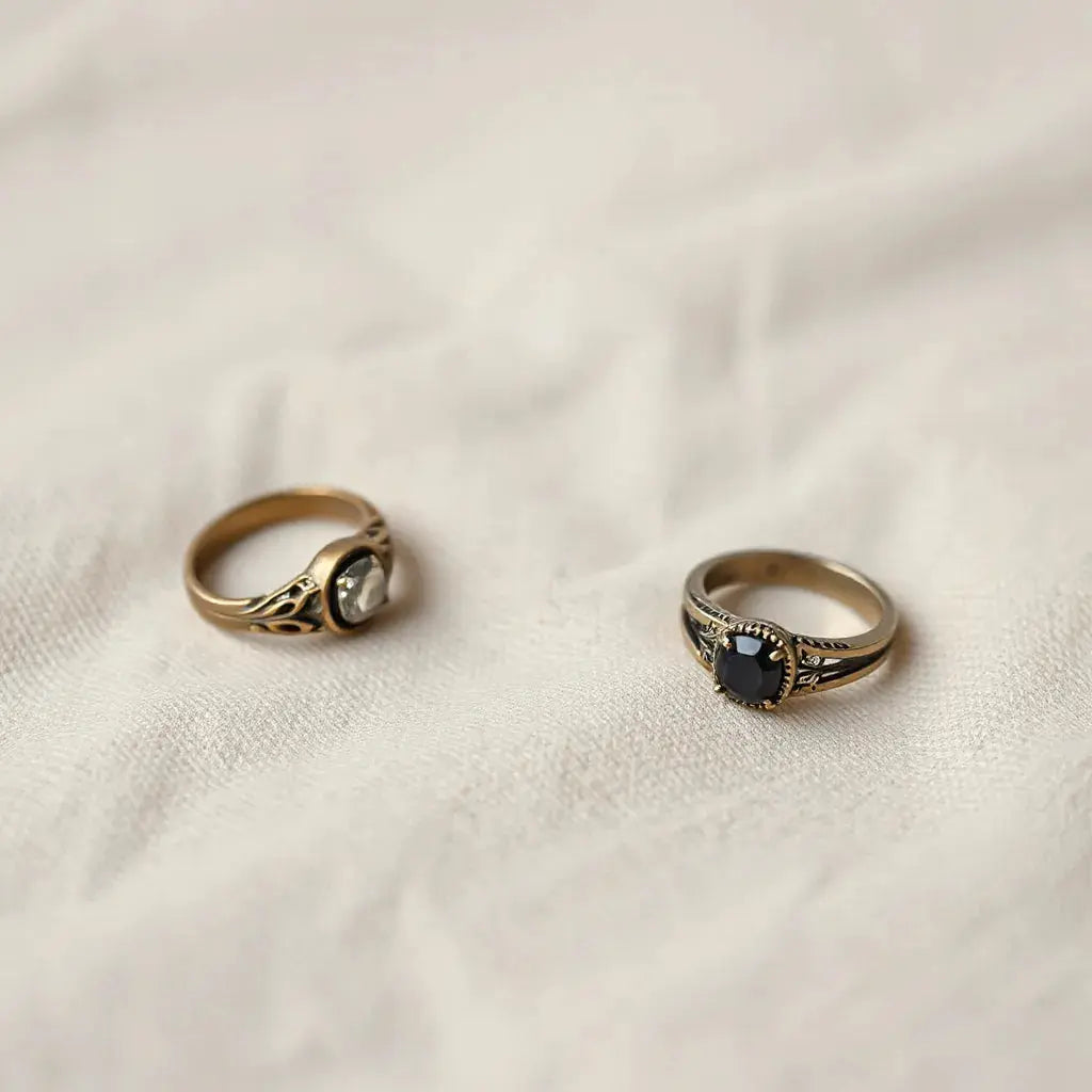 Three vintage style rings with filigree detail on neutral linen under warm soft light