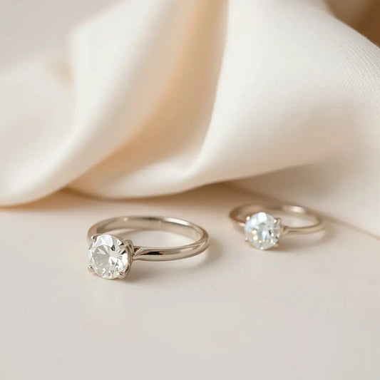 Two engagement rings with lab-grown diamonds arranged on a neutral background in soft natural light