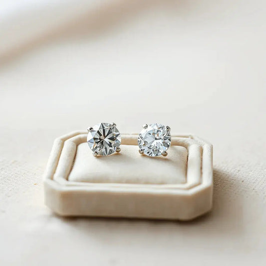 Two lab grown diamond studs with a small gem tray on a neutral background