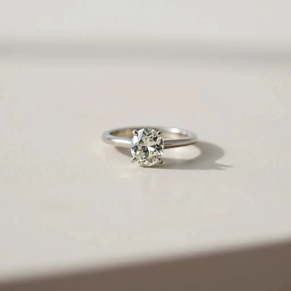 Oval diamond ring with a clear view of the stone’s facets on a neutral background