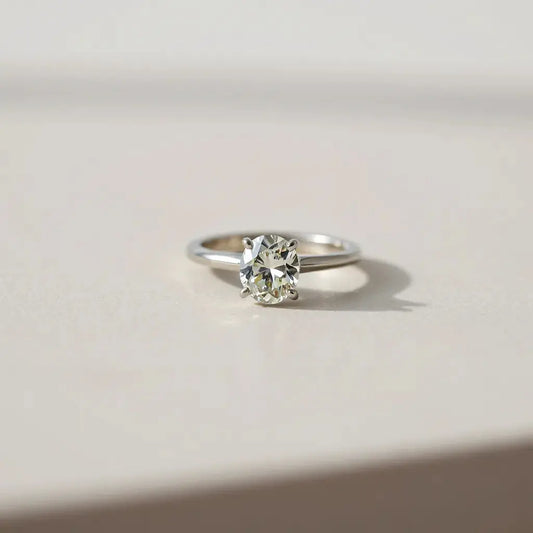 Oval diamond ring with a clear view of the stone’s facets on a neutral background