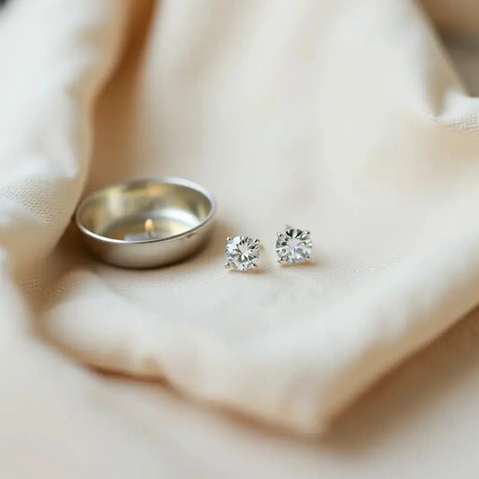 Pair of elegant diamond earrings displayed on neutral fabric with soft studio lighting