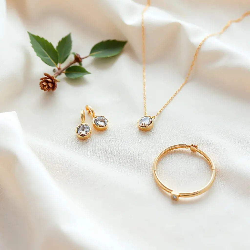Gold and gemstone earrings, pendant, and bracelet arranged neatly on soft neutral fabric with gentle light