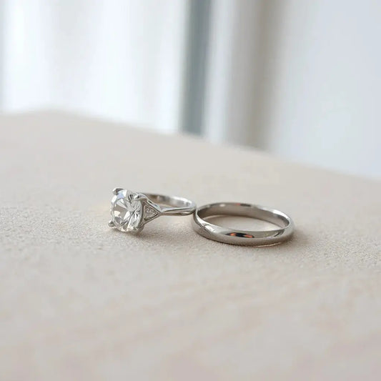 Minimal modern solitaire ring with a clear stone in a sleek prong setting on a neutral background