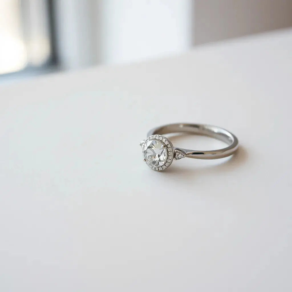 Modern engagement rings with sleek bands and a central diamond resting on a neutral background