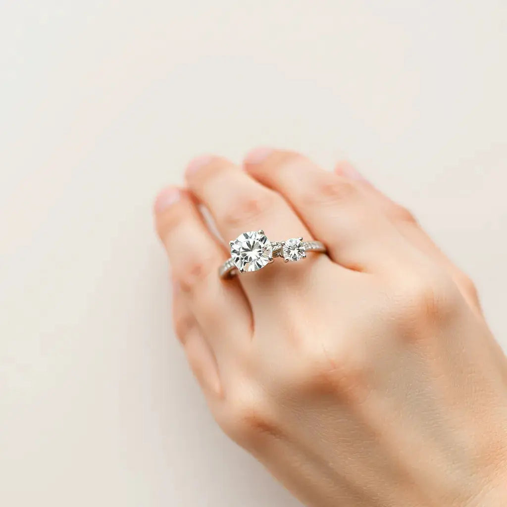 Two diamond rings with visible settings on a neutral background under soft studio light