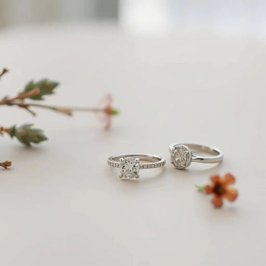 Elegant engagement rings with visible setting details on a light neutral background