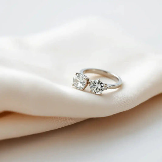 Two elegant lab-grown diamond rings with clear stones on a neutral fabric backdrop