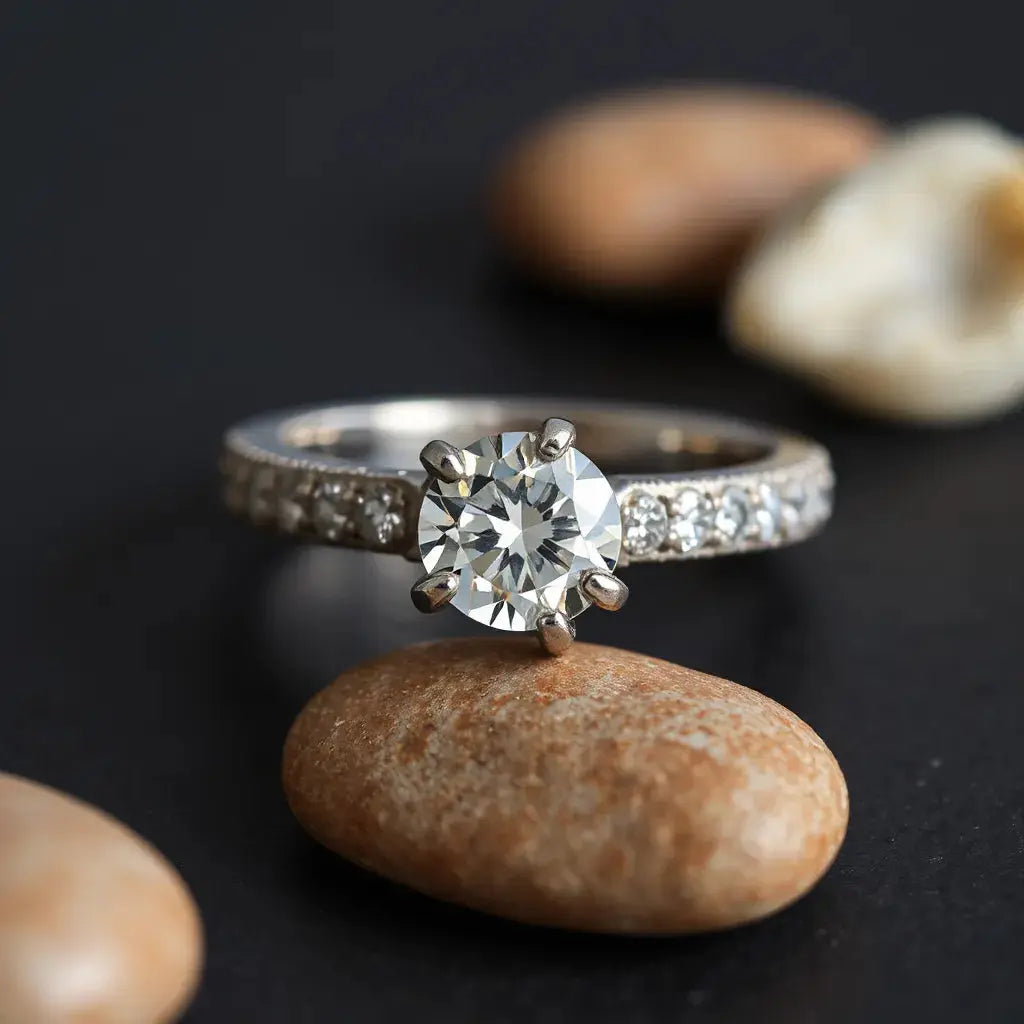 Close-up of a ring band with pavé-set diamonds and visible metal prongs under soft studio light