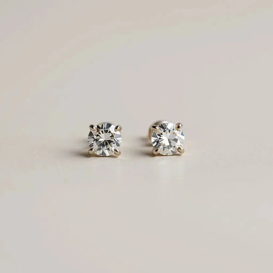 Pair of diamond stud earrings with visible sparkle on a clean neutral background