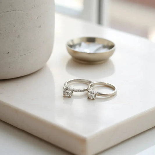 Minimalist diamond rings arranged on a neutral surface under soft natural light