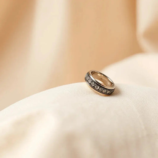 Two elegant wedding bands on neutral fabric with warm lighting and visible metal detail