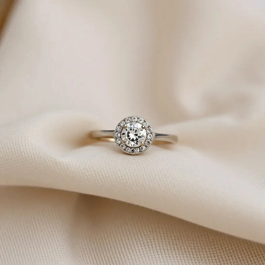 Halo engagement ring with a central diamond surrounded by a sparkling diamond halo on a neutral background