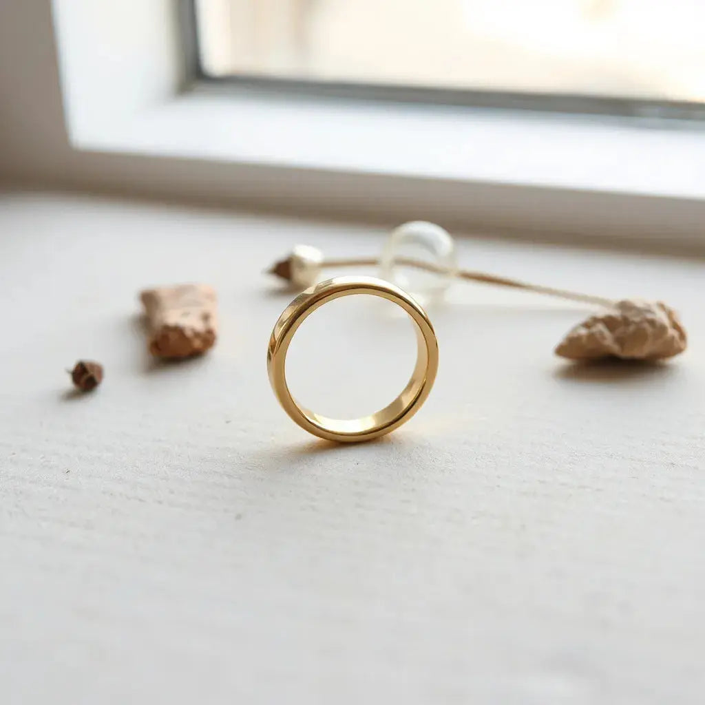 A polished 10K yellow gold ring on a neutral background with soft natural lighting