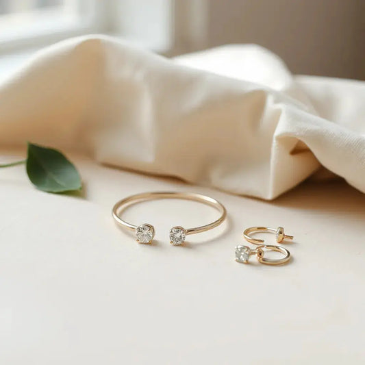 Delicate classic pendant necklace, hoop earrings, and tennis bracelet on a light linen surface