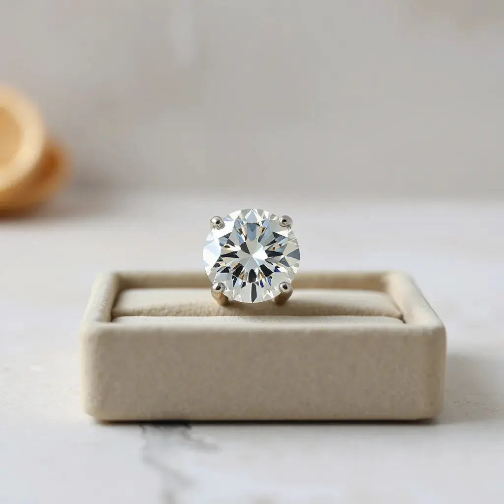 Large round brilliant diamond in a minimal prong setting with soft studio sparkle on a neutral background