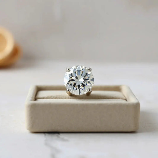 Large round brilliant diamond in a minimal prong setting with soft studio sparkle on a neutral background