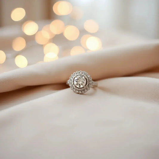 Elegant engagement ring with halo setting and brilliant center diamond on neutral fabric