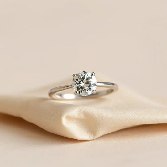 Lab-grown diamond engagement ring with a round center stone on a neutral background
