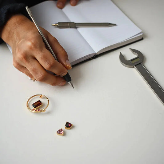 Jeweler’s hands shaping a gold framework for a custom jewellery design with gemstone accents