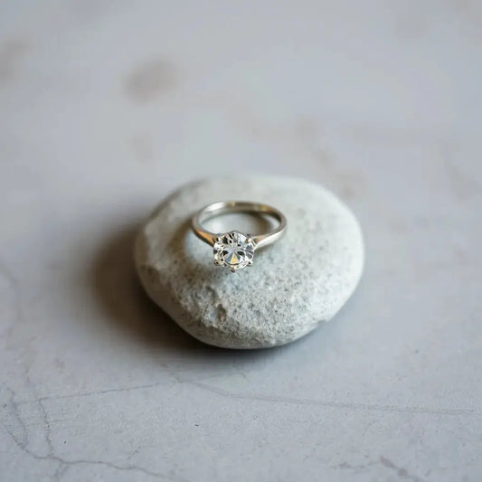 Classic solitaire ring with a round diamond on polished metal band in a clean studio setting