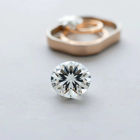 Faceted lab-grown diamond gemstone resting on a neutral tray with soft studio reflections